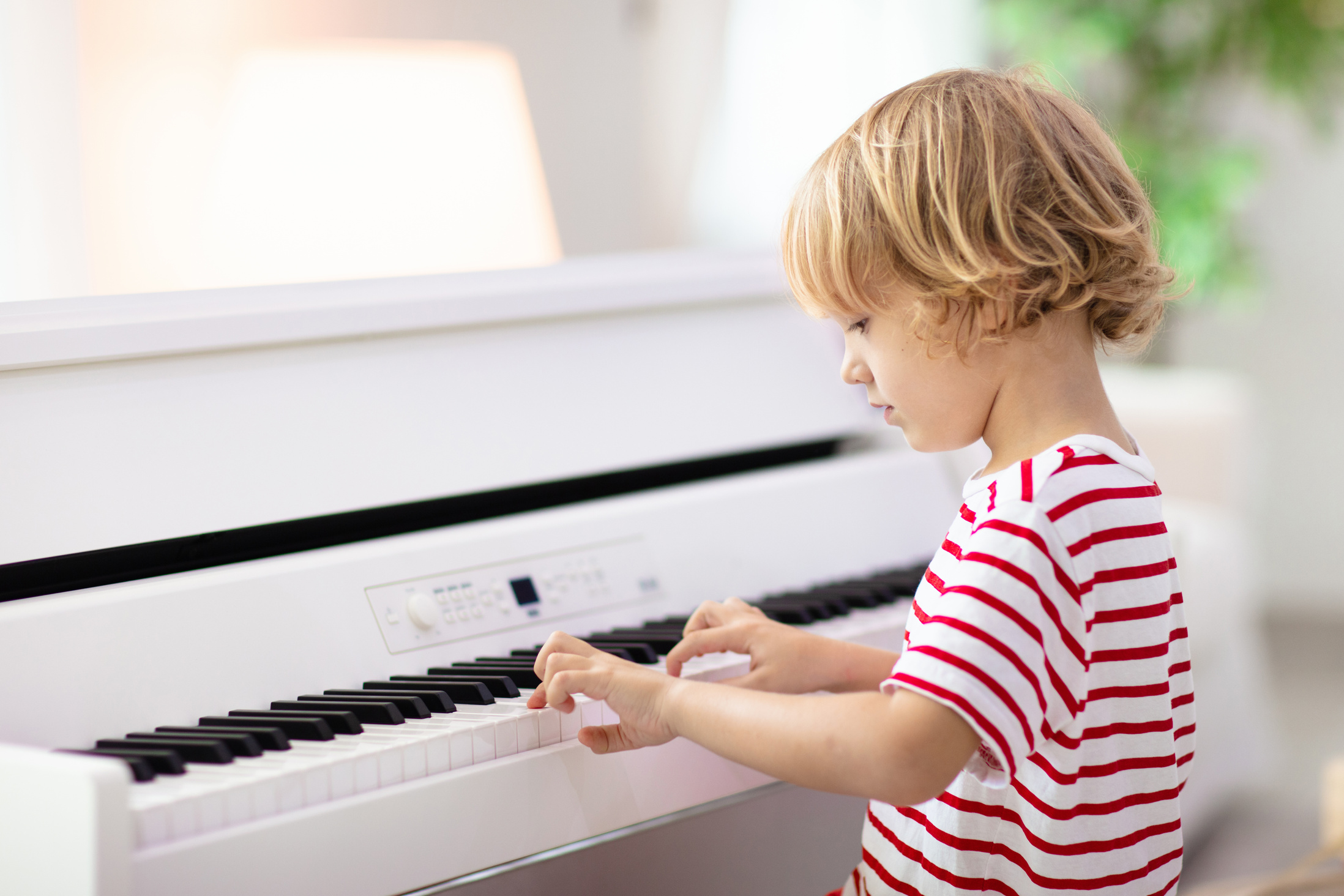 Child playing piano. Kids play music.